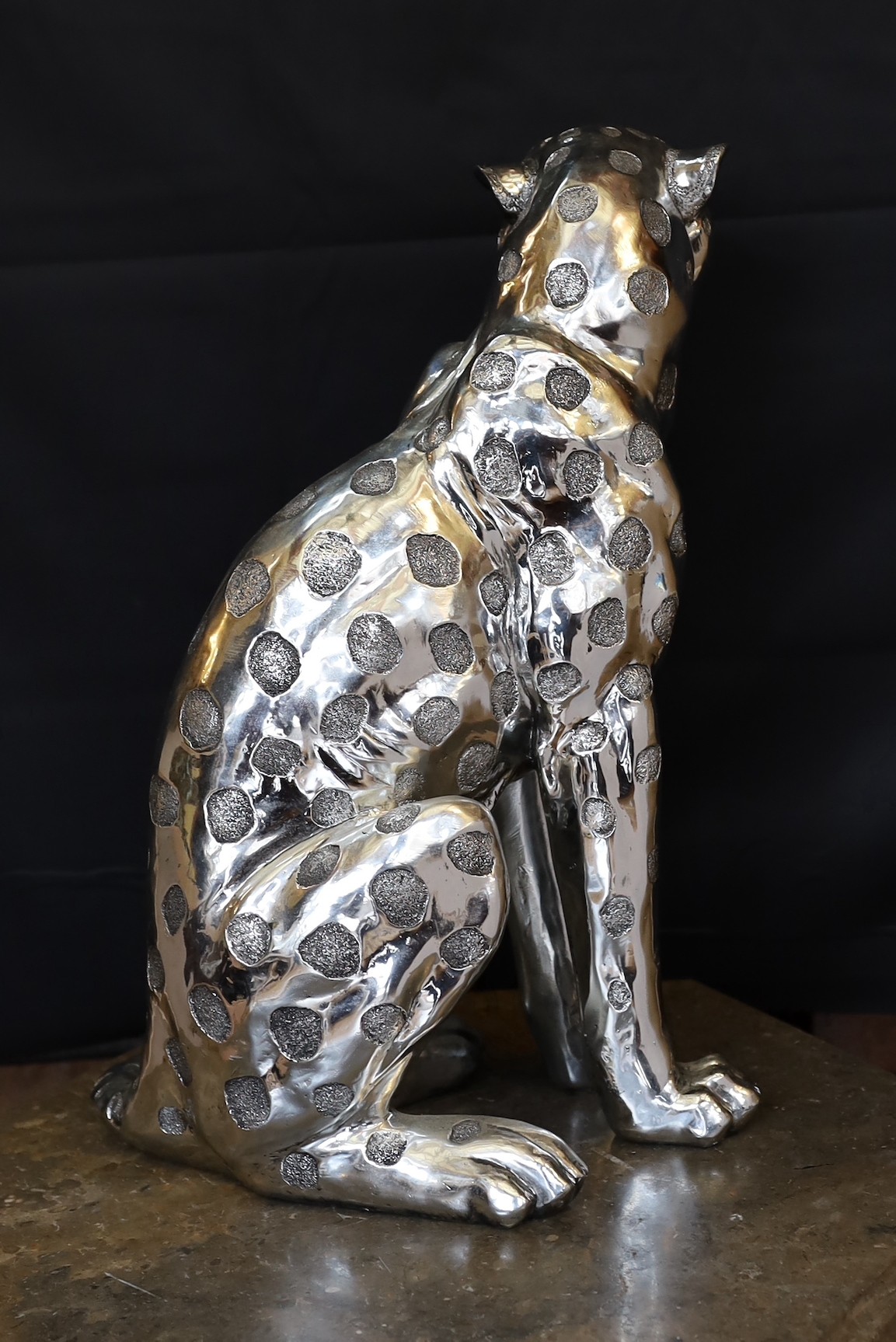 A silvered composition model of a seated leopard, height 50cm